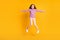 Full size photo of beautiful happy positive energetic little girl jumping having fun  on yellow color background