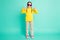 Full size photo of brown haired little girl make thumbs up wear star glasses white pants yellow turtleneck isolated on