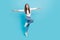 Full size photo of cheerful energetic delighted lady fooling around spread hands flying isolated on blue color