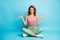 Full size photo of cheerful woman sit legs crossed enjoy peaceful calm sporty yoga exercise meditation show om sign wear