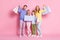 Full size photo of dream amazed family daddy mommy hold shopping bags  over pink pastel color background