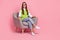 Full size photo of friendly professional psychology specialist woman waistcoat jeans sit on armchair  on pink