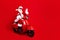 Full size photo of funky grandfather wear stylish santa costume glasses riding on red scooter say hello isolated on red