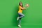 Full size photo of funky optimistic girl hold like wear t-shirt jeans sneakers  on green color background