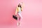 Full size photo of funky sweet lady hold boombox dance wear cap jacket trousers sneakers isolated on pastel pink color