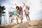 Full size photo of group overjoyed carefree people piggyback rejoice walk sand beach free time outside