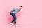 Full size photo of handsome young guy carry heavy invisible box empty space dressed trendy blue outfit isolated on pink