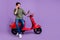 Full size photo of happy young positive man hold hand phone rider bike talk phone isolated on violet color background