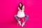 Full size photo of impressed brunette nice lady sit look empty space wear jacket jeans sneakers isolated on pink