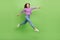 Full size photo of nice sweet optimistic girl dressed jeans purple pullover jumping running shopping isolated on green