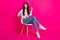 Full size photo of optimistic brunette nice lady sit blow kiss wear jacket jeans sneakers isolated on pink background