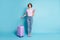 Full size photo of positive cheerful girl tourist hold baggage use smartphone booking taxi hotel wear lilac violet t