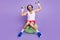 Full size photo of weak unhappy young man hold hands weights lift up sit ball isolated on purple color background