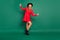 Full size photo of young beautiful happy excited crazy girl in red dress and black hat isolated on green color