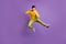 Full size photo of young crazy positive funky funny man doing karate in air jumping  on purple color background
