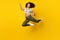 Full size photo of young excited african girl rejoice winner success jump isolated over yellow color background