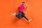 Full size photo of young handsome funky positive afro man jumping showing v-sign isolated on orange color background