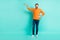 Full size photo of young handsome positive smiling man measure size height wear orange sweater isolated on teal color