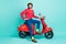 Full size photo of young handsome smiling cheerful gentleman with motorcycle isolated on turquoise color background