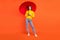 Full size photo of young woman happy positive smile walk rainy weather protection parasol isolated over orange color