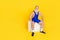 Full size portrait of extravagant sporty aged person sit podium empty space isolated on yellow color background