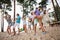 Full size portrait of group overjoyed crazy buddies chilling dancing sand beach listen guitar music outside