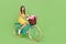 Full size profile photo of adorable positive lady ride bike fresh flowers bucket  on green color background