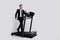 Full size profile photo of positive confident elegant person walk, treadmill empty space offer ad isolated on grey color