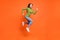 Full size profile sid photo of young active crazy girl have fun enjoy run jump happy smile isolated over orange color