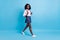 Full size profile side photo of black schoolgirl happy smile go walk step lesson isolated over blue color background