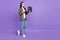 Full size profile side photo of positive focused businesswoman go walk working in laptop isolated on purple color