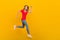 Full size profile side photo of young girl runner hurry motion speed jump discount isolated over yellow color background