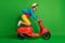 Full size profile side photo of young happy crazy excited girl ride fast red moped isolated on green color background