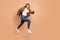 Full size profile side photo of young scared afraid girl running in air hold tablet look copyspace isolated on beige