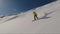 Full speed riding in backcountry on a snowboard in a sunny winter day in the mountains