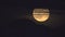 Full super moon through wispy clouds over mountains Iceland