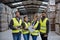 Full team of warehouse employees standing in warehouse. Team of workers in reflective clothing in modern industrial