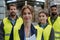 Full team of warehouse employees standing in warehouse. Team of workers in reflective clothing in modern industrial