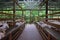 Full wide view of goat farm barn surrounded with green trees