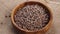 Full wooden bowl of uncooked lentils on a rustic rough burlap.