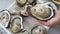 Full yummy opened giant oyster in a Shell serving on lady cheft hand`s, Freshness seafood from fishery boat at fresh market