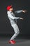 Fullbody portrait of young cool man dancing on dark background.