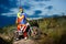 Fully Equipped Professional Downhill Cyclist with Bike on the Night Rocky Trail