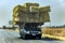 A fully laden car carries straw bales from the field.