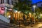 Fully occupied tables and chairs at a restaurant in evening