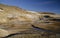 Fumarole fields of Iceland covered with yellow brimstone with boiling mud craters against the winter sky