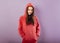 Fun enjoying toothy smiling sporty woman posing in fashion red hoodie on purple bright background with empty copy space. Happy