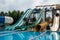 Fun fast slides in an aquapark. Summer vacation entertainment ideas. Colorful slide variety and turquoise swimming pool at a hotel