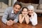 Fun on the floor with granny and gramps. A girl lying down and smiling at the camera with her grandparents.