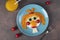 Fun Food for kids - smiling face ginger girl made from fried eggs, carrot, cucumbers and cherry tomatoes on blue plate